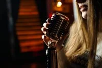 side view woman singing microphone &copy;freepik