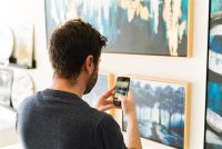 Rear view of a latin man taking a picture of a beautiful canvas he liked © Antonio Diaz